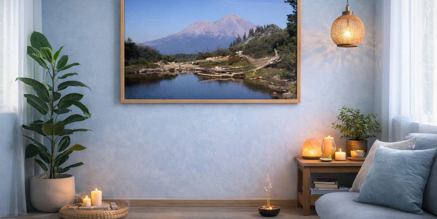 Living room with a large framed picture of a mountain landscape, candles, and a plant.